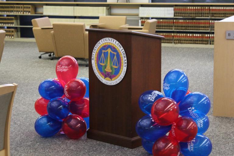 RCLL podium with red and blue balloons.