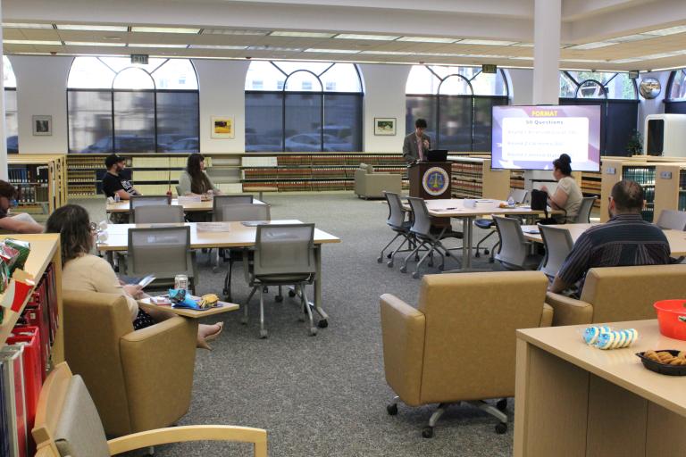 A library staff member presents trivia to patrons.