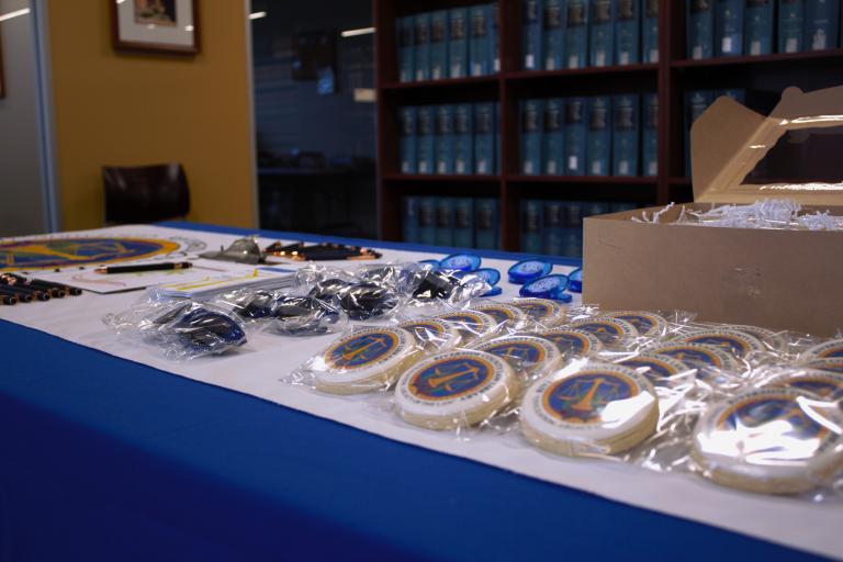 A display of RCLL cookies, sunglasses, pens, and magnets on a table inside the Palm Springs Law Library.