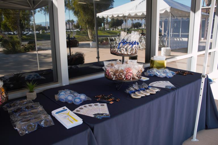 A tabletop display of Law Library swag and baked goods outside the Palm Springs Courthouse.