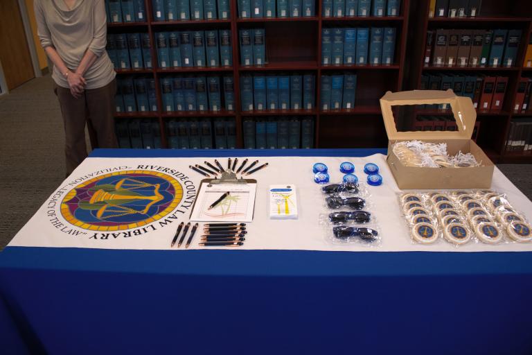 A tabletop display of Law Library swag and cookies at the Palm Springs reopening.