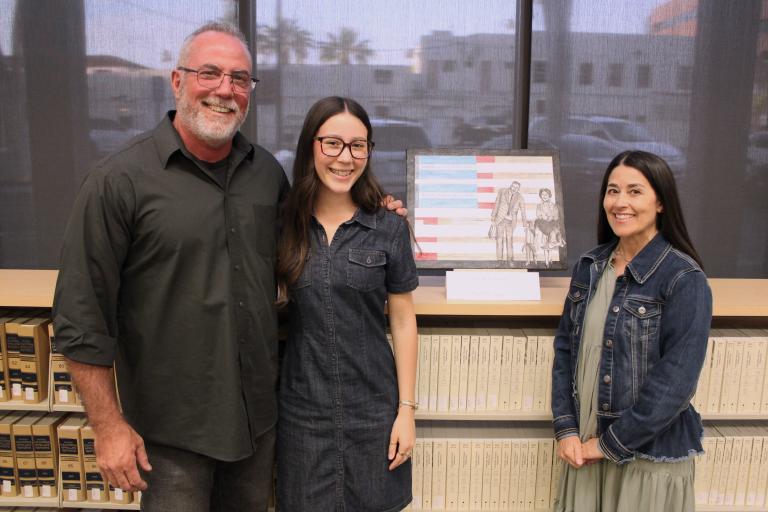 Second place winner Ava Felis with her parents and artwork, "Excited to Be Here"