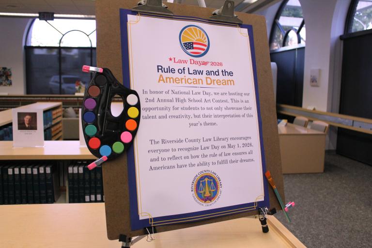 Standee for Law Day 2026. "Rule of Law and the American Dream. In honor of National Law Day, we are hosting our 2nd Annual High School Art Contest. This is an opportunity for students to not only showcase their talent and creativity, but their interpretation of this year's theme. The Riverside County Law Library encourages everyone to recognize Law Day on May 1, 2026 and to reflect on how the rule of law ensures all Americans have the ability to fulfill their dreams."