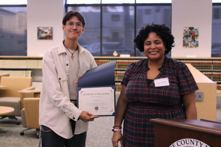 Administrative Officer Lauren Patterson presents the first place certificate to Liam Montes.