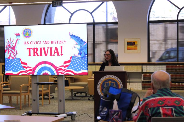 User Experience Librarian Andrea Valencia delivers remarks at Trivia Night