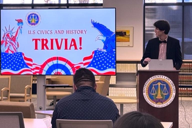 Library Assistant Matthew Palacios emcees Trivia Night.