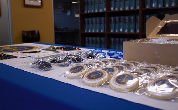 A display of RCLL cookies, sunglasses, pens, and magnets on a table inside the Palm Springs Law Library.