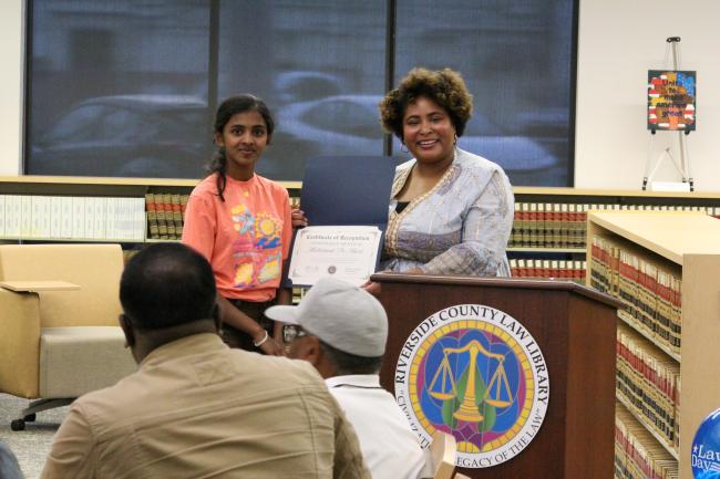 Methsandi De Alwis being handed an award by Lauren Patterson