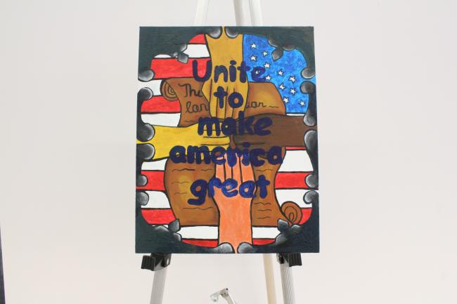 The piece consists of four hands meeting in the middle, symbolizing unity, on top of the Constitution which is layered on top of the US flag. In front of the hands is written, “Unite to make America great.” De Alwis named her piece “Unity for a better country through the Constitution’s Promise,”