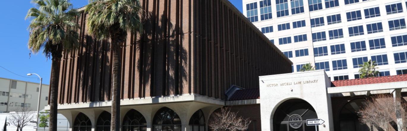 law library building with palm trees out front against a blue sky