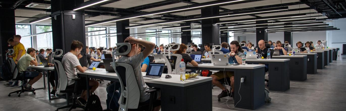 a room full of people sitting at desks with computers