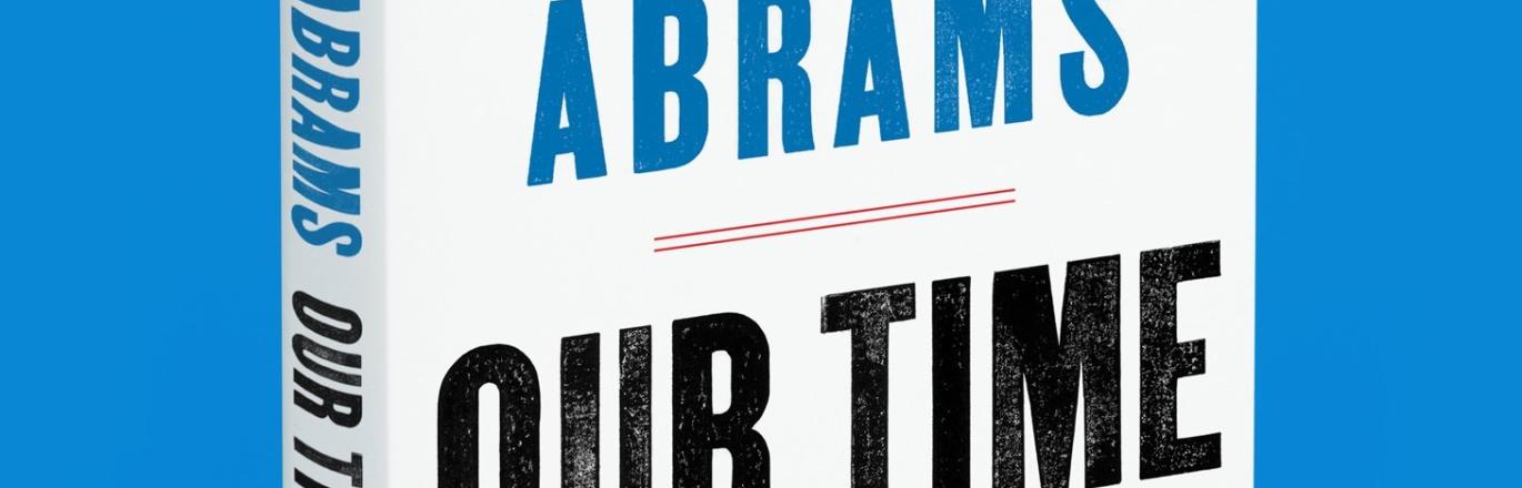 light blue background with Stacey Abram's book displayed upright
