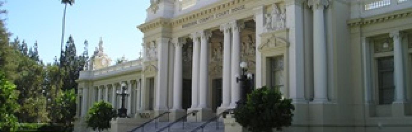 white courthouse building with green grass and blue sky