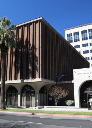 law library building with palm trees out front against a blue sky
