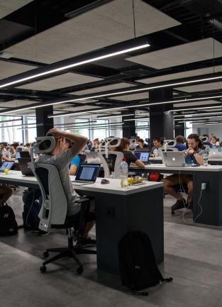 a room full of people sitting at desks with computers
