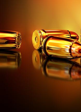 3 pairs of 2 golden/copper like bullets, 2 pairs on their sides and one pair upright on a reflective surface