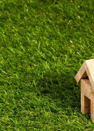 a wooden jenga like house structure on green grass